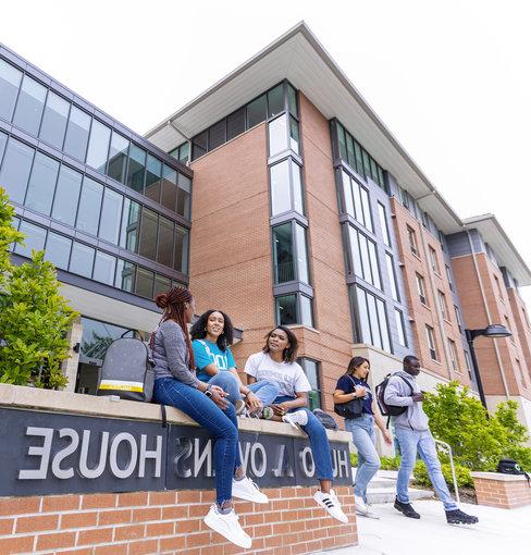 Students sitting and talking in front of Hugo Owens residence hall